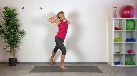 Frau in Sportkleidung führt eine Übung auf einer Matte in einem hellen Fitnessraum mit Trainingsgeräten aus.