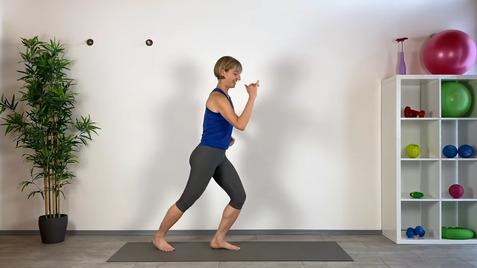 Sportlerin in blauer Oberbekleidung führt eine Fitnessübung auf einer Matte vor einer weißen Wand aus.