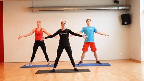 Drei Personen in Sportkleidung machen Übungen auf Matten in einem Fitnessraum.