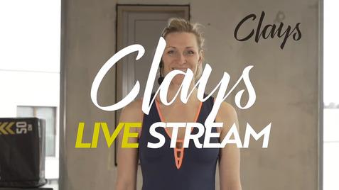 Lächelnde Frau in Sportkleidung vor einem neutralen Hintergrund, mit Text „Clays LIVE STREAM“ im Bild.