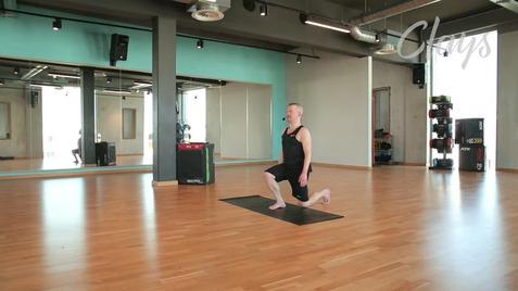Mann in Sportkleidung führt im Studio einen Ausfallschritt auf einer Trainingsmatte aus. Spiegel im Hintergrund.